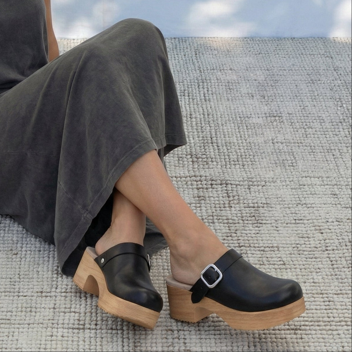 Person wearing black leather Calou flex-sole clogs