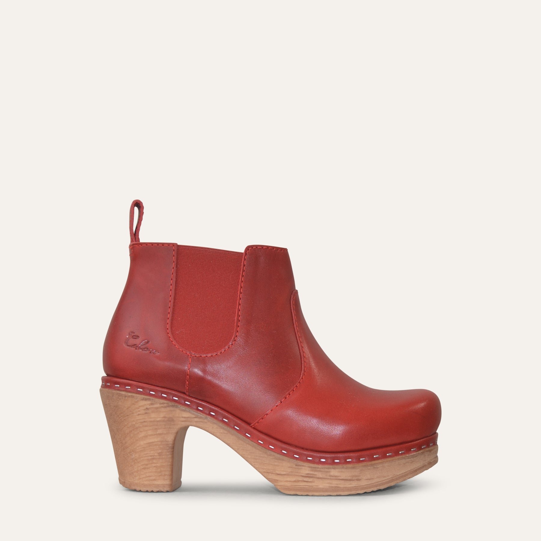 Red leather ankle boot with wood-look heel on a white background