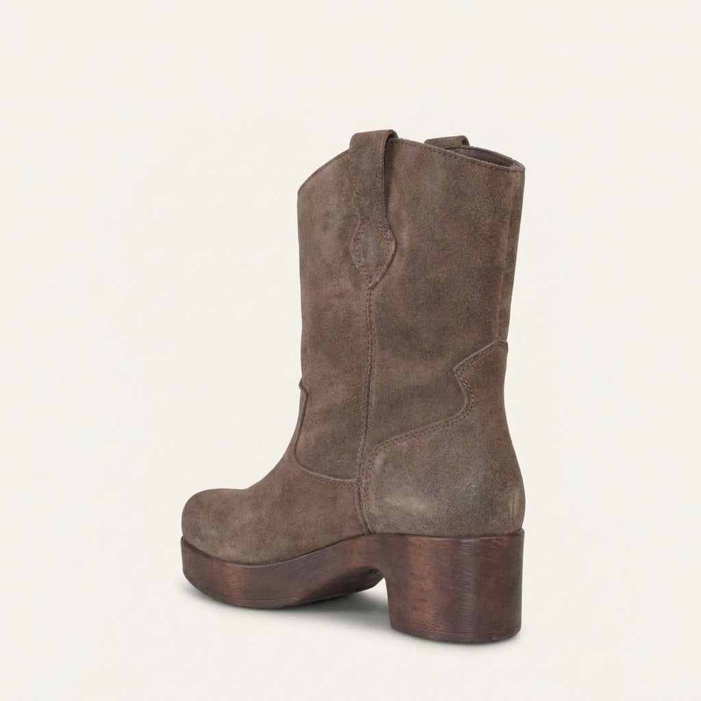 A single mid-calf western-style boot in distressed brown suede, shown from a three-quarter rear angle on a light cream background.