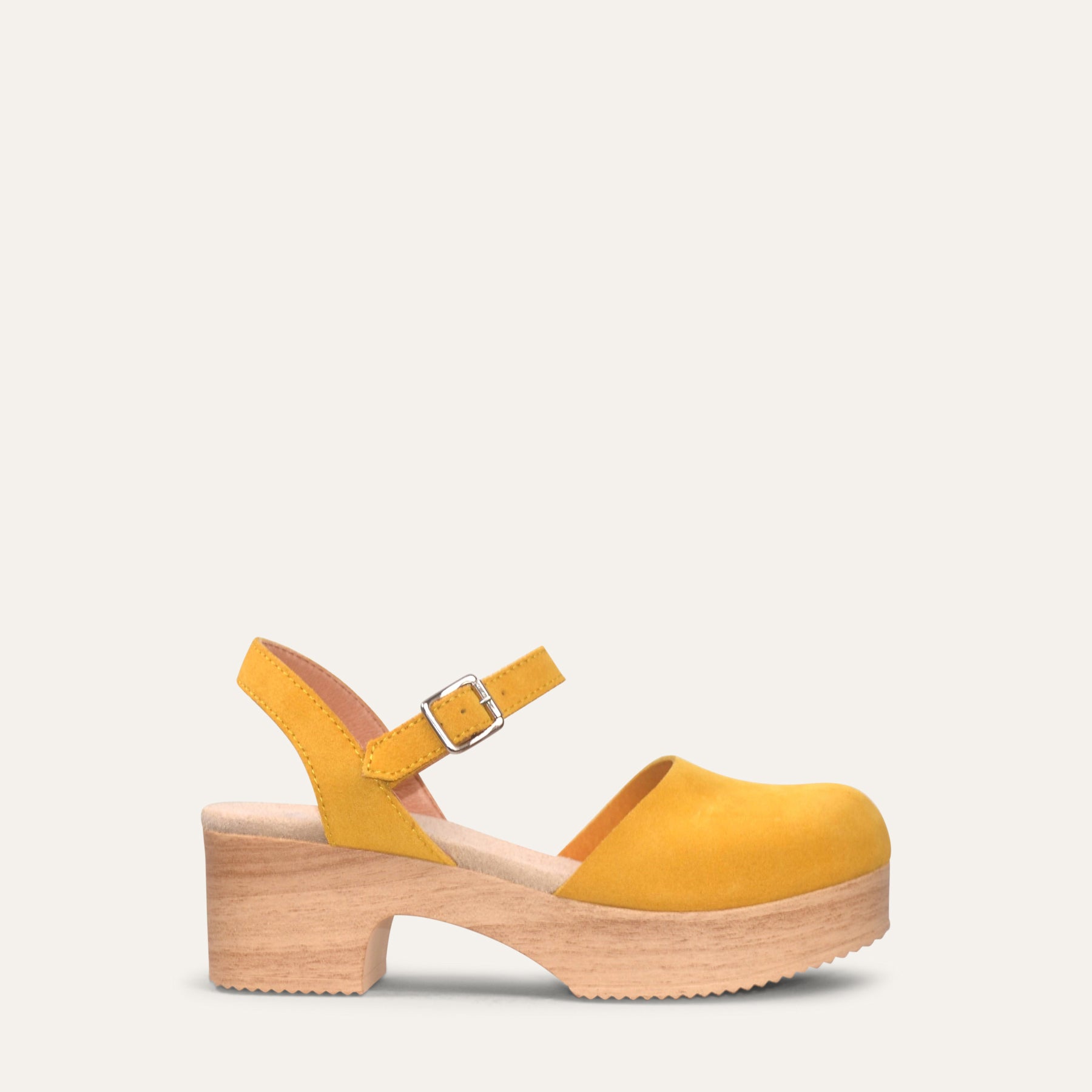 Yellow clog shoe with wooden sole on a light gray background